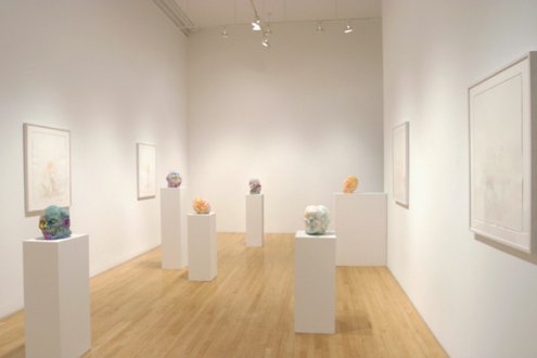 installation view of exhibition heads on pedestal and work on wall