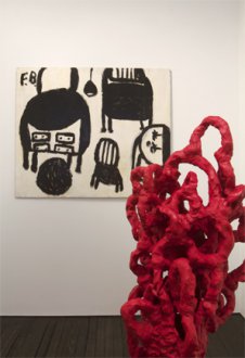 red sculpture in front of black and white painting