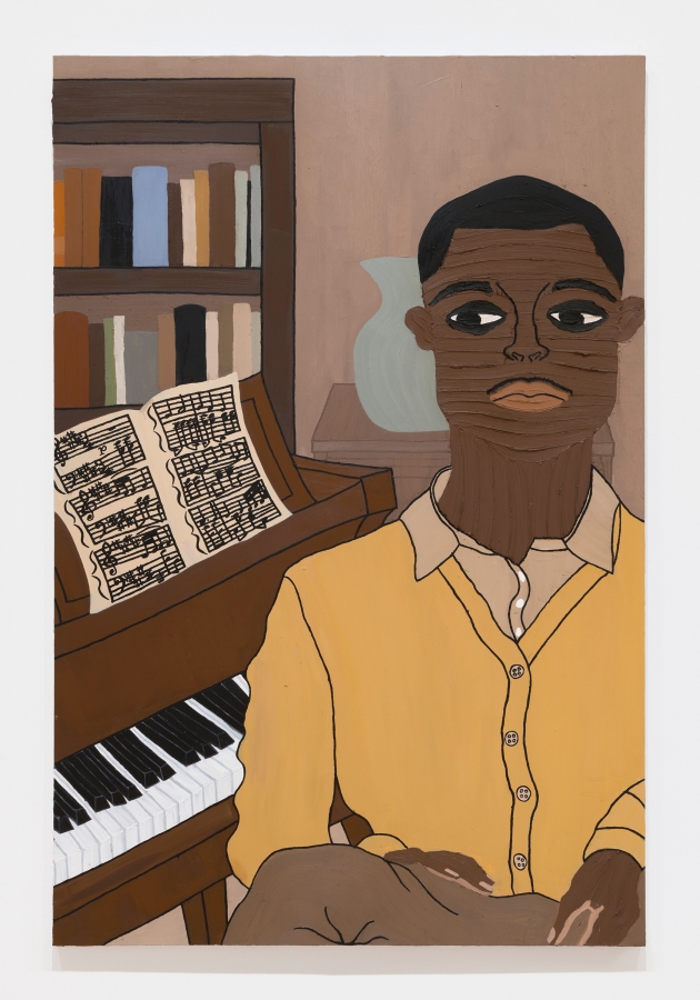 A young man sits alone at a piano with a bookshelf behind him