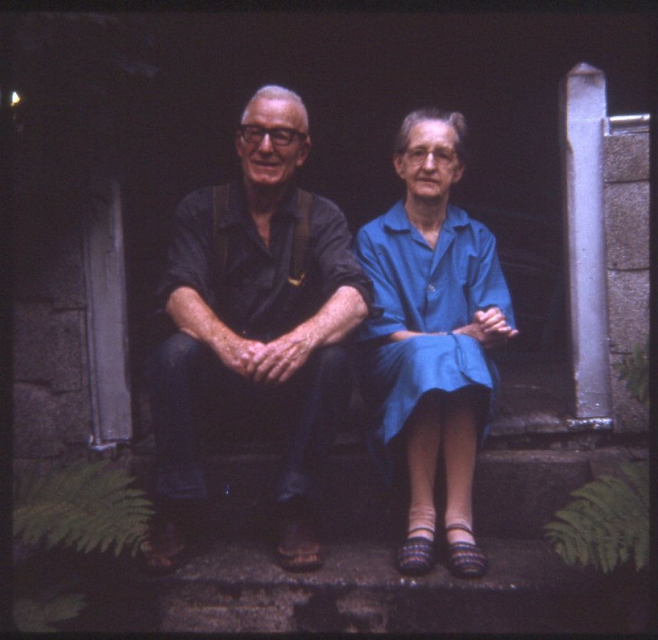 Portrait of the artist Clarence Swinyer and his wife sitting on the stairs of their home