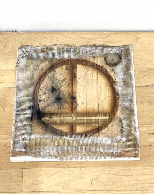 circle burnt in wood square placed on floor