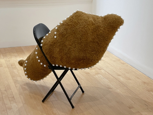 sculpture with folding chair and stuffed shape