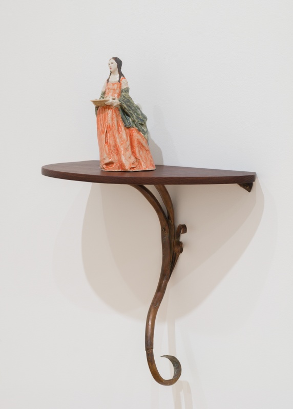 Mary Carlson sculpture of Dorothea, patron saint of gardens, on a wood pedestal with vine motif