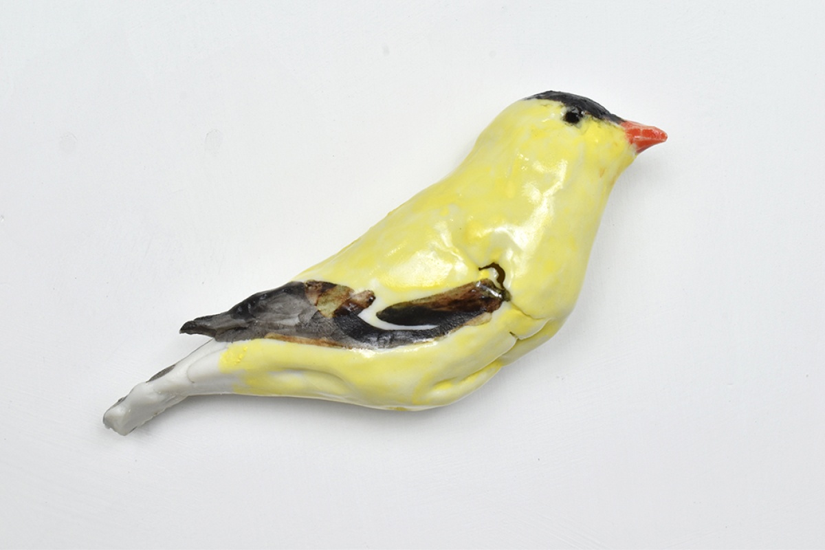 Mary Carlson sculpture of small yellow goldfinch bird