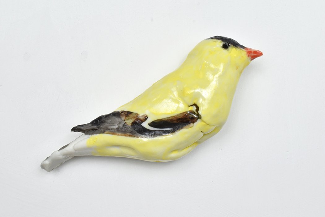 Mary Carlson sculpture of small yellow goldfinch bird